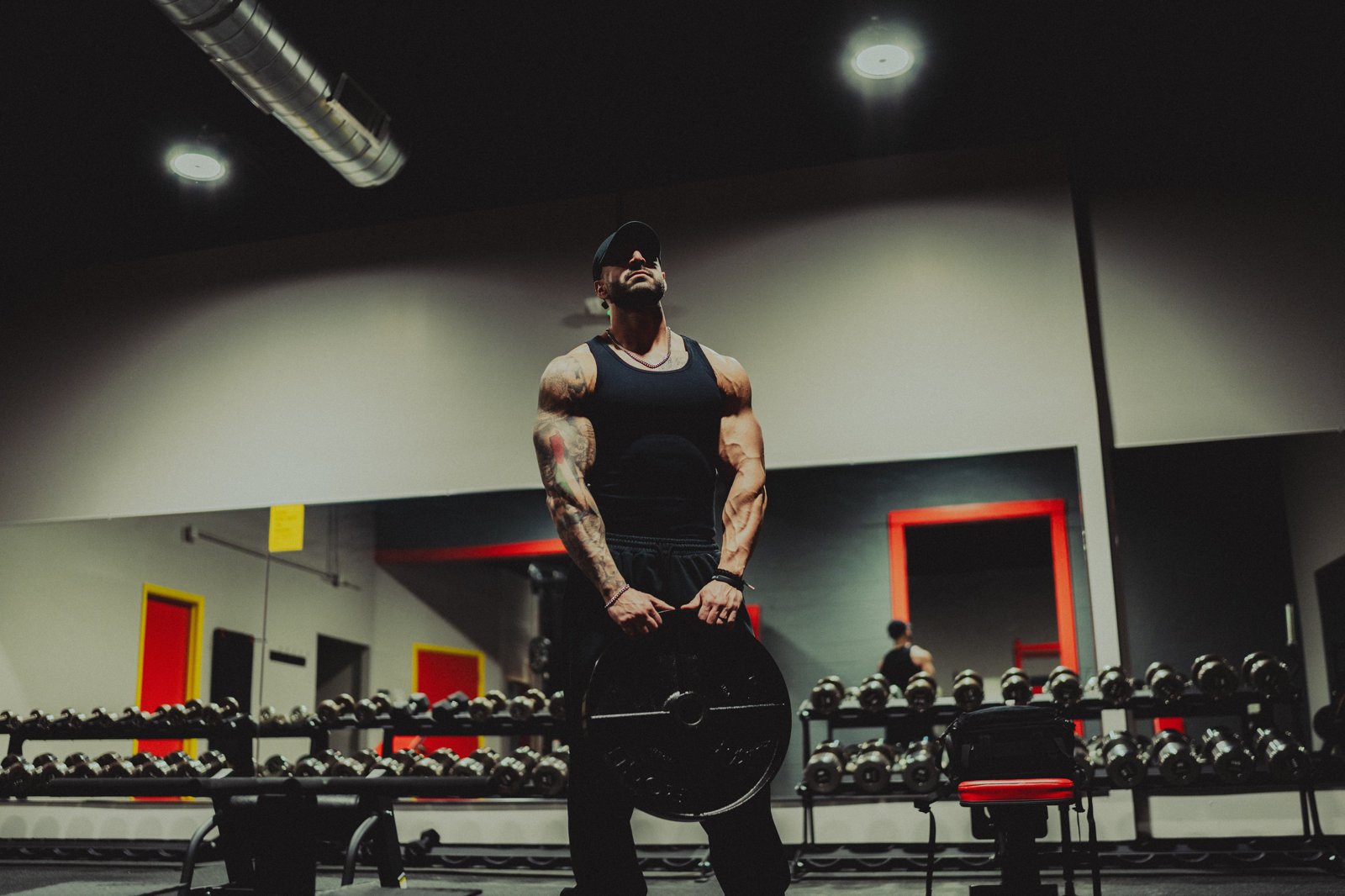 Coach lifting a weight plate in the gym